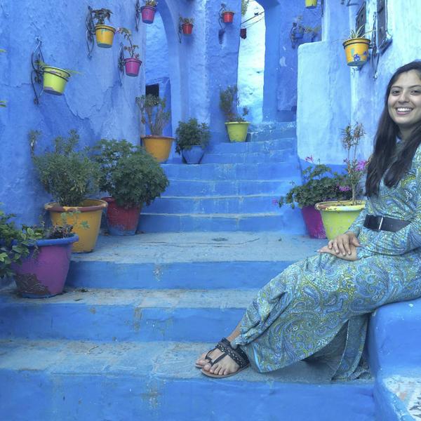 a young woman sits on a painted staircase in Greece