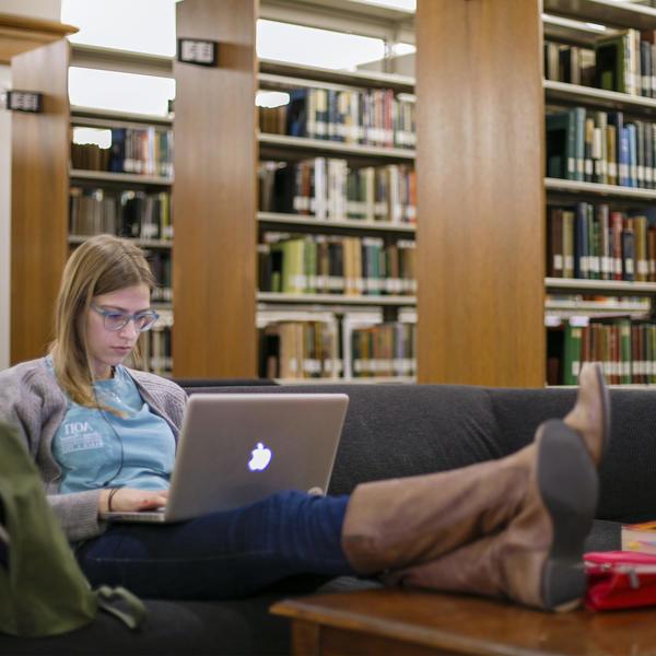 A student studying on their laptop in the library.